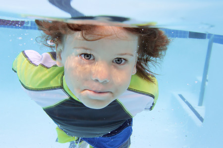 Child swimming in pool underwater, summer or sports themeの写真素材