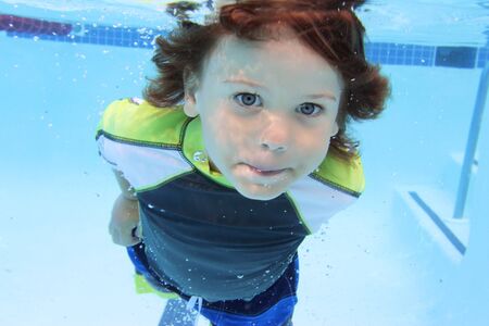 Child swimming in pool underwater, summer or sports themeの写真素材