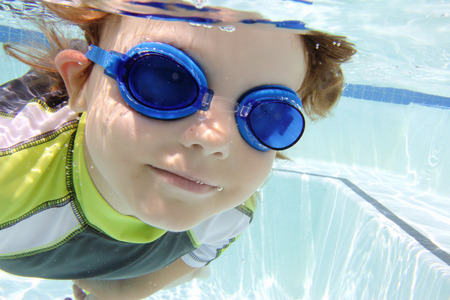 Child  diving and swimming in pool underwater, summer or sports themeの写真素材