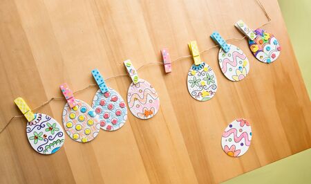 Easter activities and crafts project: colorful easter eggs decorated with pencils and markers and stickers, made into a bannerの写真素材