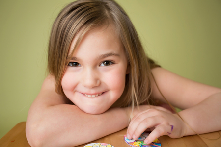 Child doing Easter activities and crafts with Easter Egg shapes, pencils and markers.の写真素材