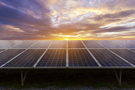 Blue photovoltaic solar panels on ground mounting at twilight ,Clean energy.