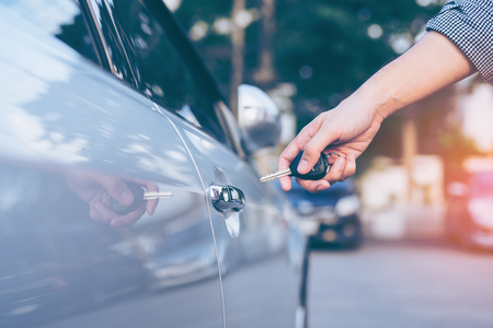 Men's hand using key unlock doors car の写真素材