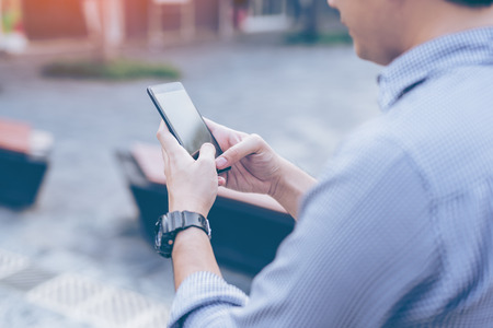 Young asian handsome businessman concentrated while reading his smartphone. Portrait of asian...
