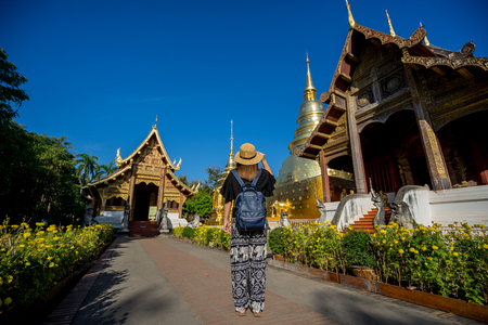 Young woman traveler traveling to Wat Phra Singh temple. This temple contains supreme examples of Lanna art in the old city center of Chiang Mai,Thailand.のeditorial素材