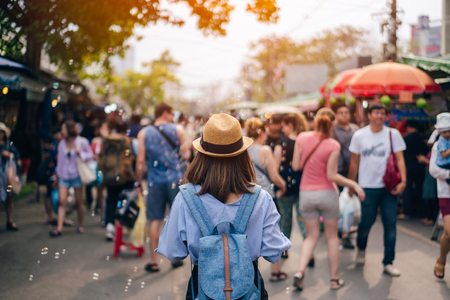 Young woman traveler with sky blue backpack and hat looking the way with in JJ Market in Bangkok Thailand. Traveling in Bangkok Thailandのeditorial素材