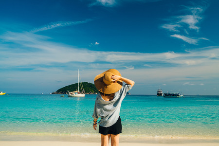 Rear view of young woman traveler with hat relaxing on the beach at similan islands in Andaman sea...