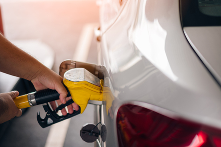 Man holding pumping gasoline fuel in car at gas stationの写真素材