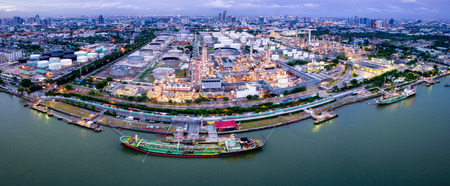 Aerial view of oil refinery near international port at night. Panorama of refinery plant at sunset....