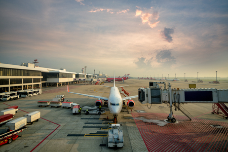 Modern passenger airplane parked to terminal building gate at international airport.のeditorial素材