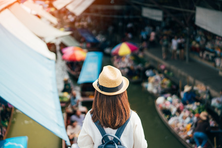 Young asian woman traveler visiting in Damnoen Saduak floating market is the most famous traditional floating market in Thailand at Damnoen Saduak district in Ratchaburi province near Bangkok Thailandの写真素材