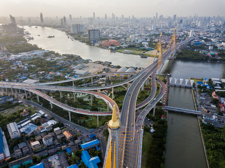 Aerial view of Bhumibol suspension bridge cross over Chao Phraya River in Bangkok city with car on the bridge at sunset sky and clouds in Bangkok Thailand.の写真素材