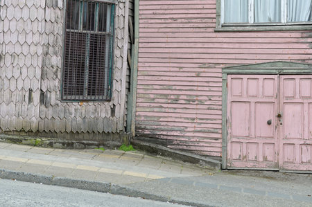 Horizontal image of an old wooden tiled facade house on a downhill streetの写真素材