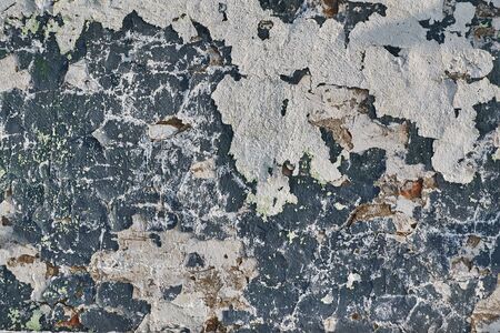 wall of red brick under two layers of delaminated stucco