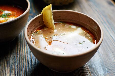 Solyanka, traditional Russian dishes, soup broth of smoked. Wooden background.
