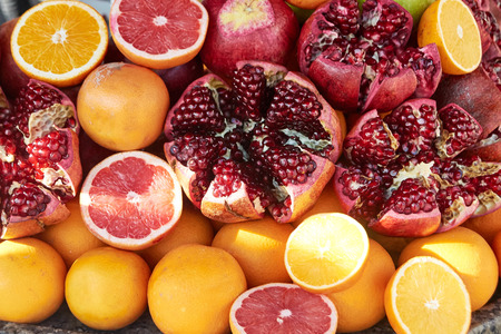 Background from fresh ripe juicy pomegranates and orangesの写真素材