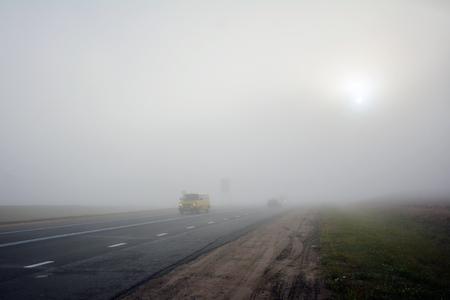 Car on the road in the fog. Autumn landscape.の写真素材