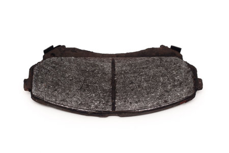 Old brake pads must be replaced on an isolated white background. Very worn out brake pads threatening road safety.の写真素材