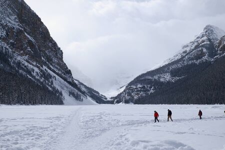 people walking on the frozen Lake Louise in winterの写真素材