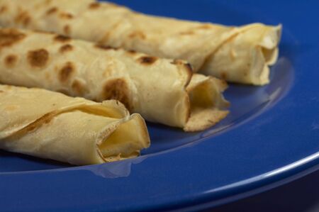 Close-up of three rolled pancakes in a blue plateの写真素材