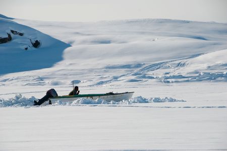 A fisher in his motorboat waiting on icefield