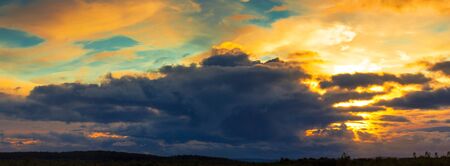 A bright glow in the sky over the hills at sunsetの写真素材