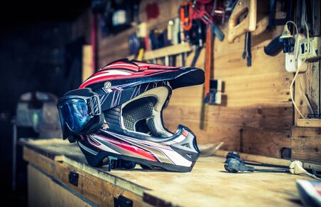 Motocross helmet with goggles on the workbench in the garageの写真素材