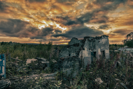 The remains of destroyed houses at sunsetの写真素材