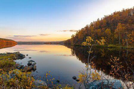 Lake in the autumn forest at sunsetの写真素材
