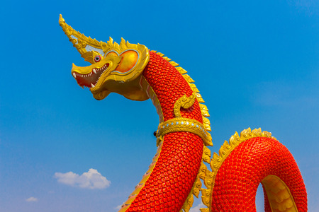 serpent king or king of naga statue in thai temple on blue sky backgroundの写真素材