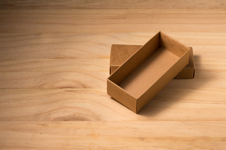 Opened cardboard box on wooden backgroundの写真素材