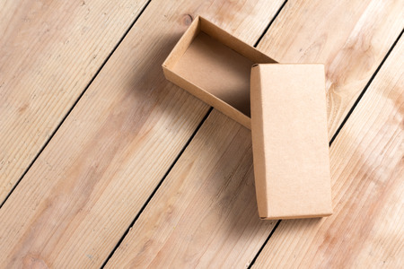 Opened cardboard box on wooden background