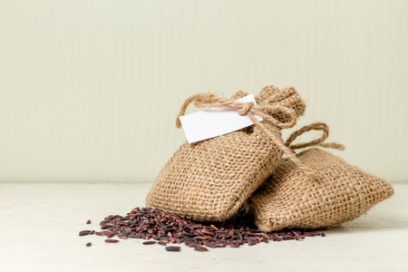 brown rice in sack bag on table whiteの写真素材