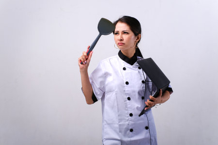 Portrait of a female chef holding a ladle and a folderの写真素材