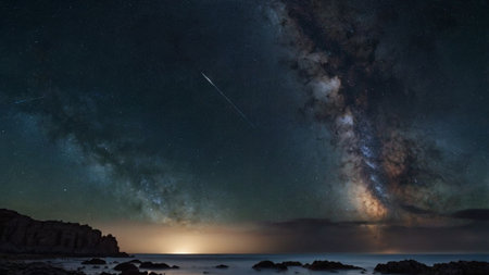 Milky way over the sea, starry sky and rocks.