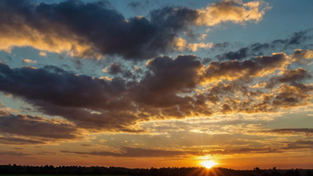 Sunset over the field. Beautiful sky with clouds at sunset.の写真素材