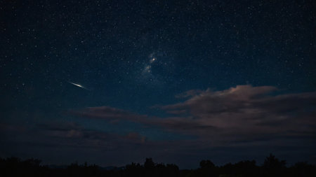 Night sky with stars and clouds. Long exposure photograph with grain.の写真素材