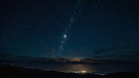 Milky way in the night sky with stars and silhouette of mountain
