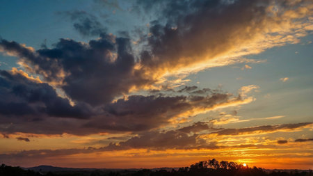Sunset sky with clouds and silhouette of trees. Nature background.の写真素材