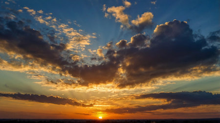 Sunset sky with clouds and sunbeams. Nature background.の写真素材