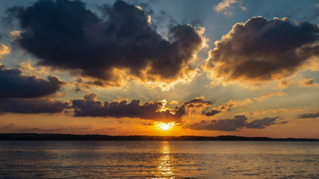 Beautiful sunset over the lake. Dramatic sky with clouds at sunset.の写真素材