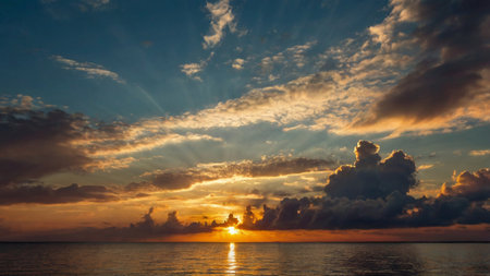 Beautiful sunset over the sea with dramatic clouds and sunbeamsの写真素材