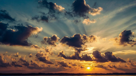 Beautiful sunset over the lake with clouds and rays of light.