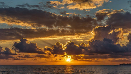 Sunset over the sea with clouds in the sky and sun rays