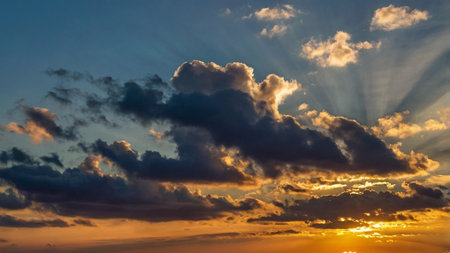 Sunset sky with clouds and sunbeams. Nature background.の写真素材