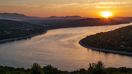 Sunset over the Danube River in Serbia with mountains in the backgroundの写真素材