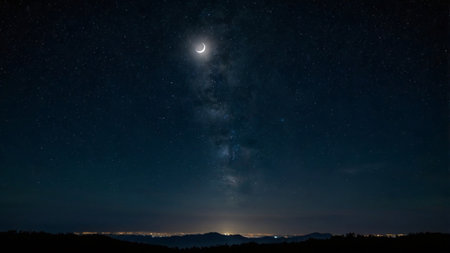 Night sky with stars and milky way. The moon over the mountains.の写真素材