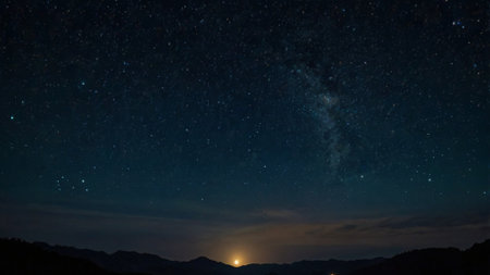 Milky way and stars in the night sky with silhouette of mountainsの写真素材