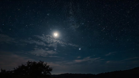 The moon and stars shine in the night sky. Long exposure photograph.の写真素材