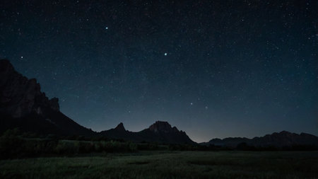 Milky Way over a meadow at night with mountains in the backgroundの写真素材
